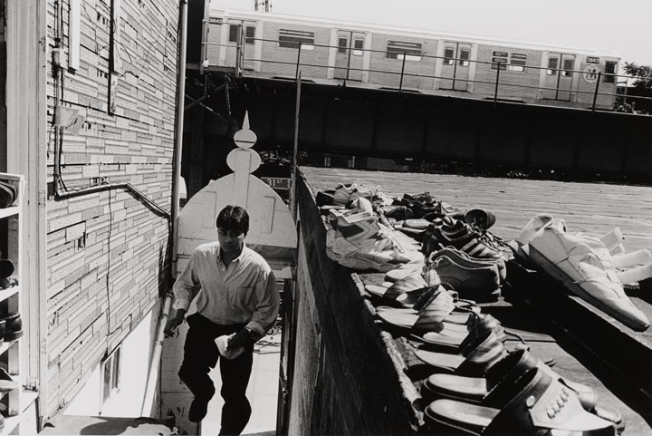 A man climbing stairs, pairs of shoes are nearby suggesting he is going to a mosque to pray