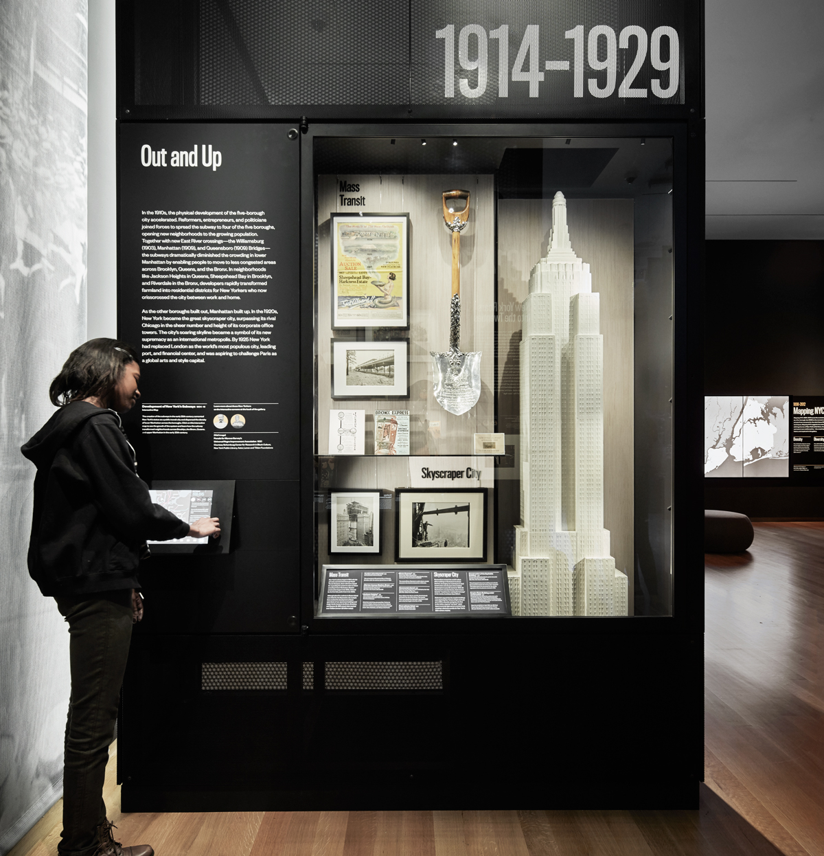 A visitor uses an interactive screen to learn more about the exhibition in front of her