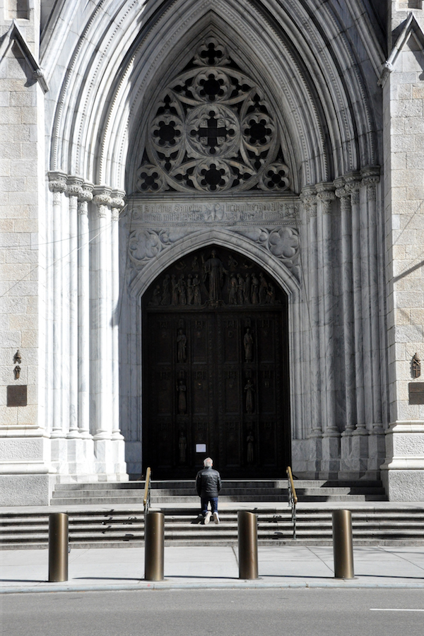 Someone prays outside of St. Patrick's Cathedral