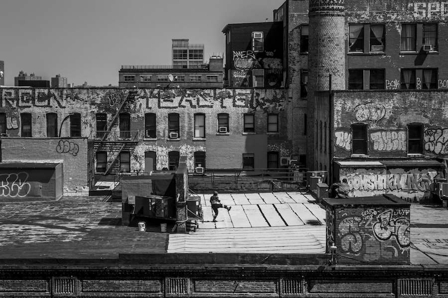 A man dances on an empty rooftop.