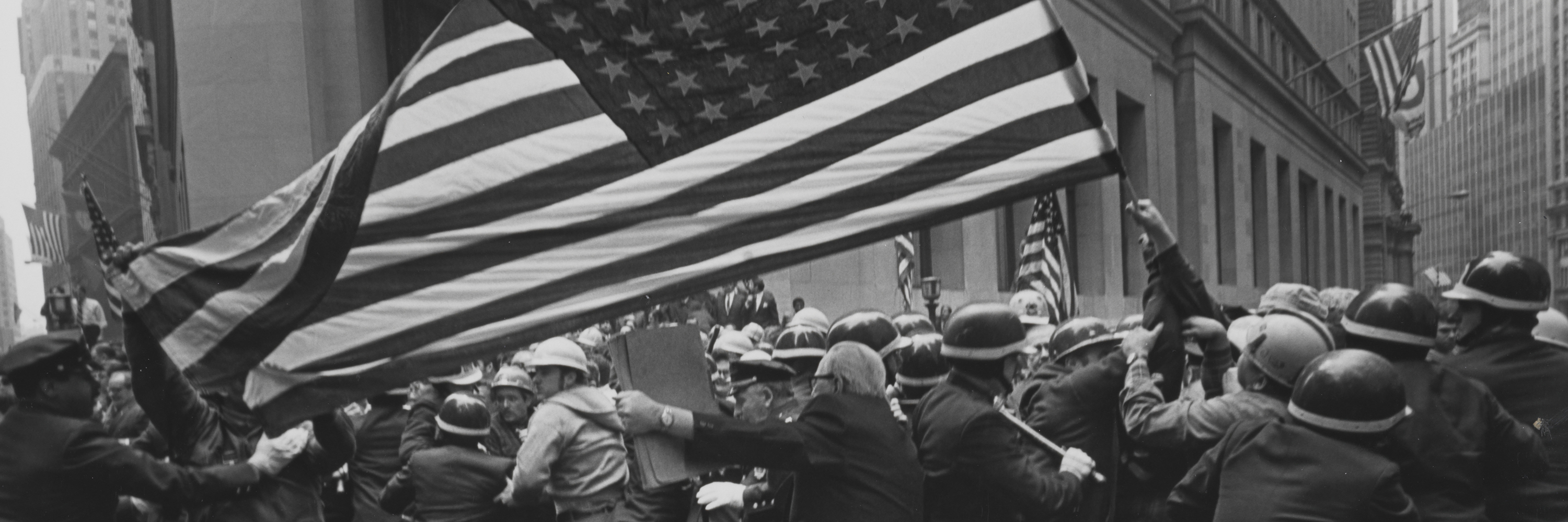 A crowd of protesters at a Pro-Vietnam-War demonstration holding a large American flag