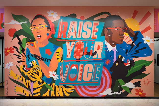 Photograph of the immersive installation "Raise Your Voice," original artwork of activists and allies Yuri Kochiyama and Malcolm X by artist Amanda Phingbodhipakkiya.
