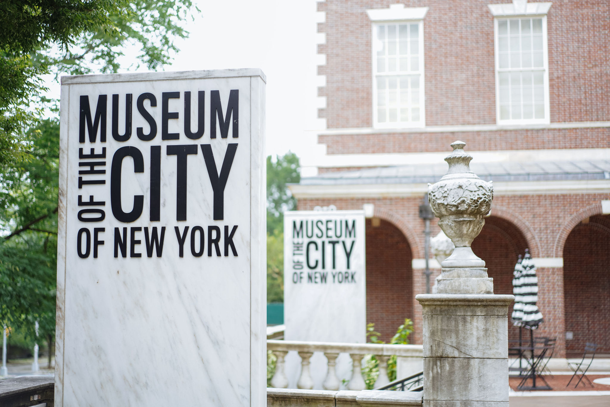 Vista del frente del Museo tomada desde la terraza que da a la esquina norte. En primer plano hay un cartel de mármol con el logo del Museo de la Ciudad de Nueva York.
