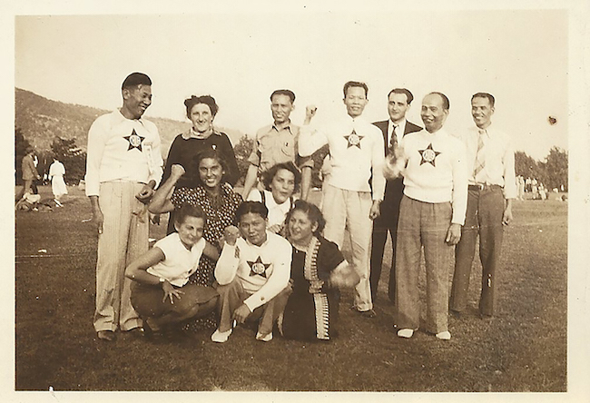 A group of men and women stand in a field