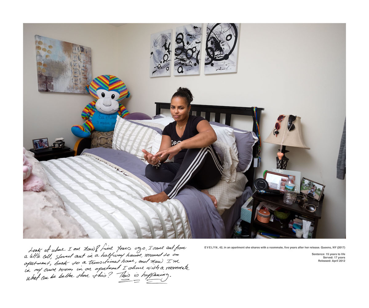 A woman sits on a bed.