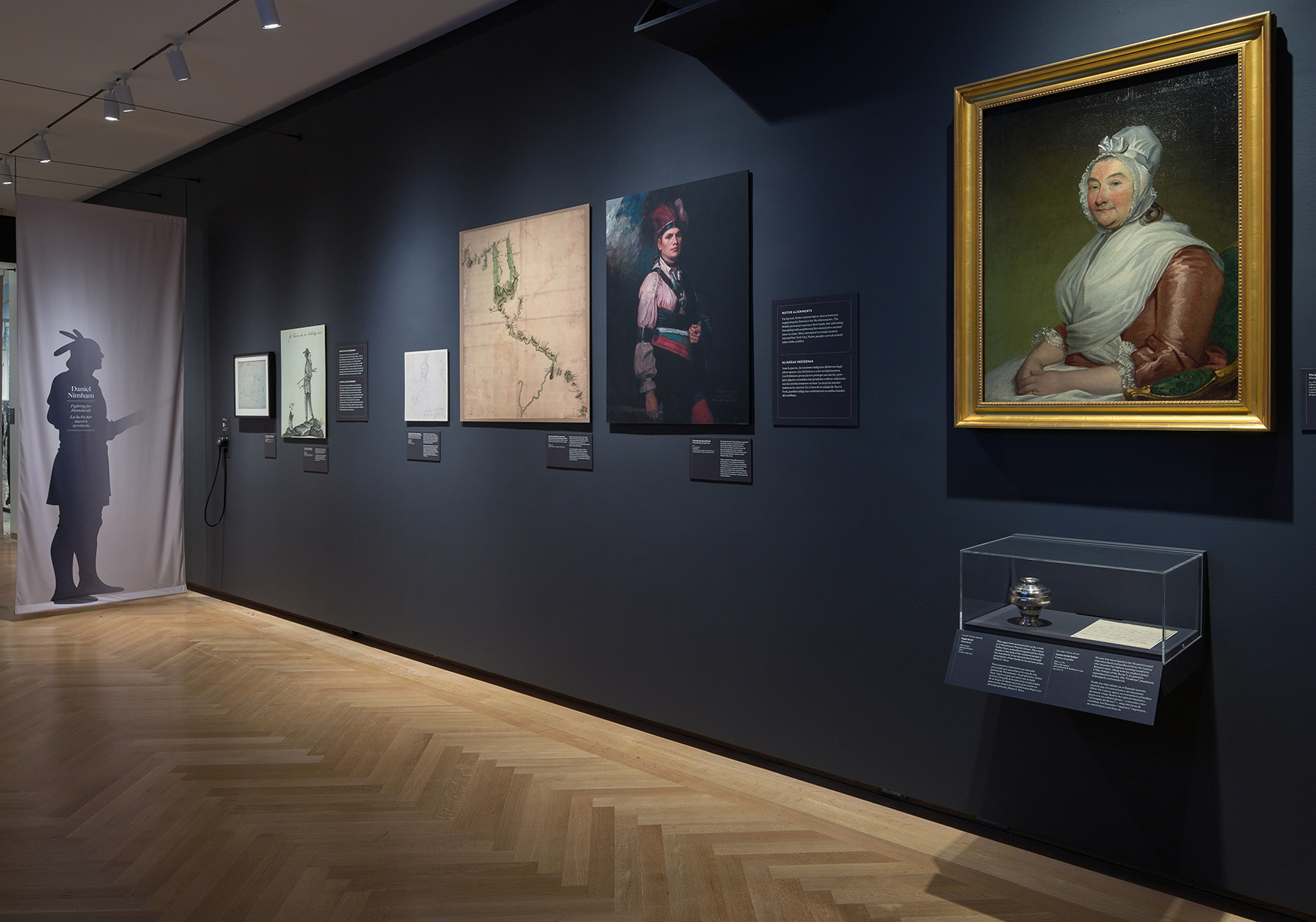 Installation view of the galleries, showing hanging banners and artwork on the walls.