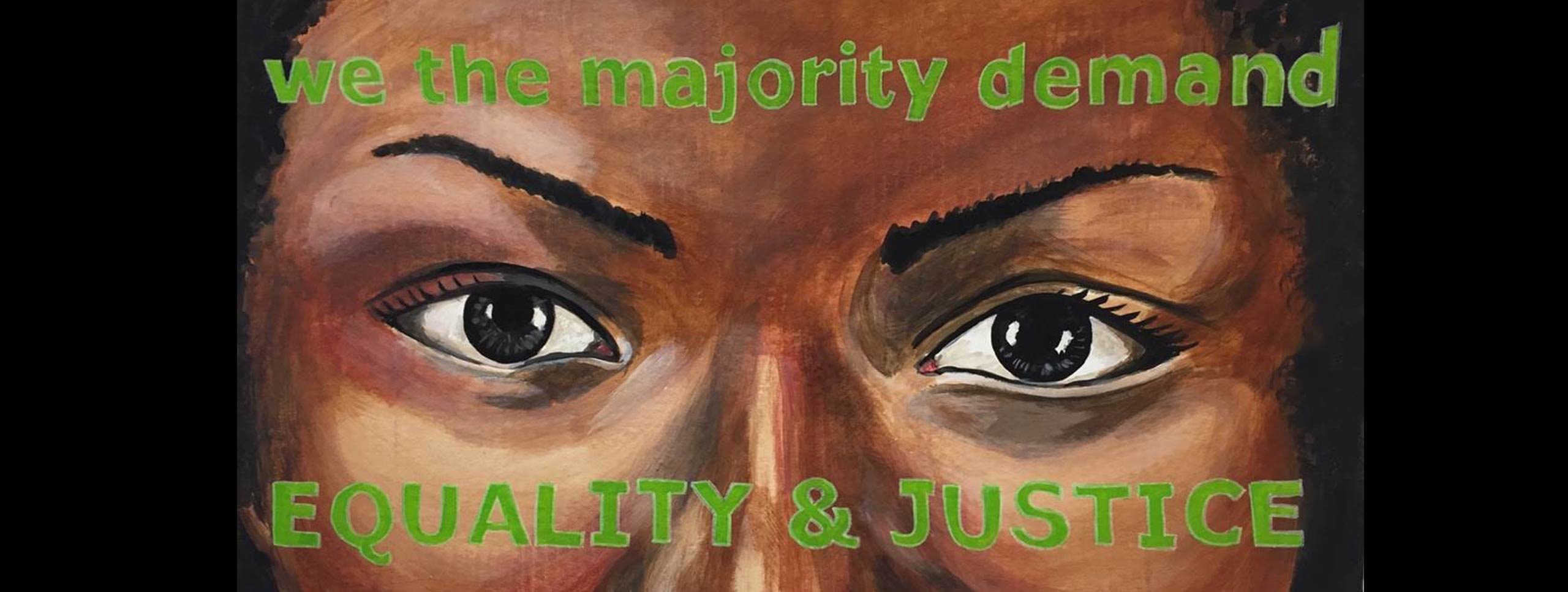 Painting of a woman’s eyes. Painted over her forehead and cheeks are the words “we the majority demand/EQUALITY & JUSTICE” 