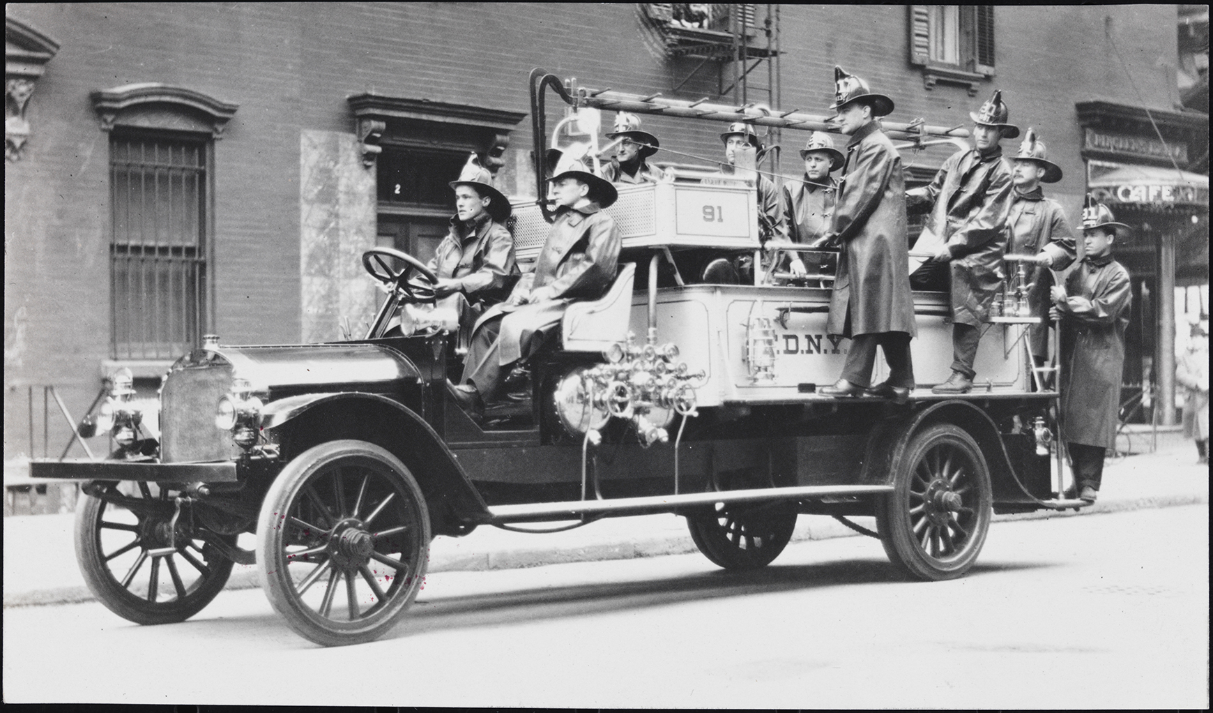 Firemen on a fire engine from the early 1900s