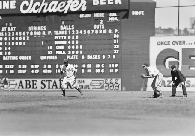 Jackie Robinson dirige bases durante um jogo no Ebbets Field com o Brooklyn Dodgers