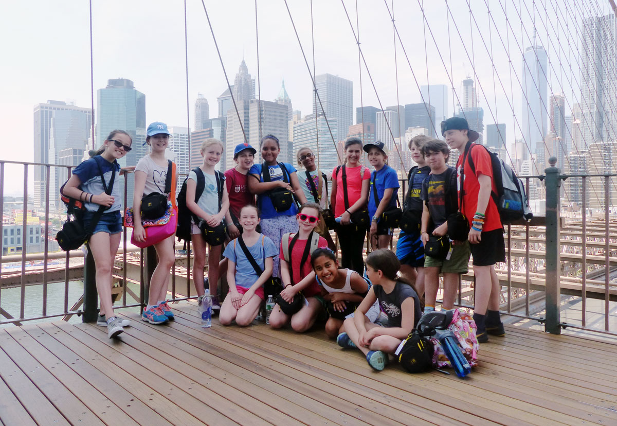 Un groupe d'étudiants posent pour un portrait sur le pont de Brooklyn