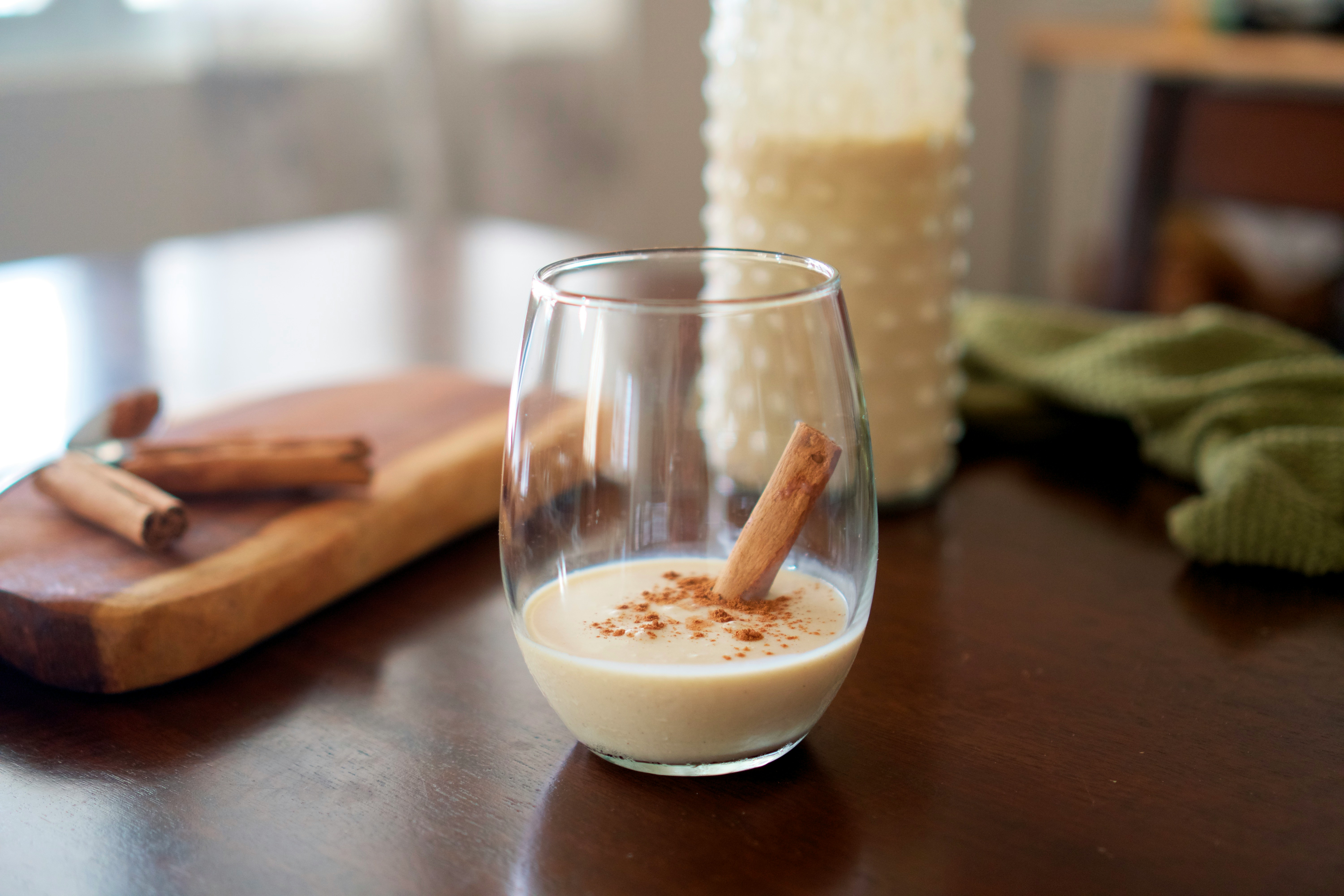 A glass of coquito on a brown table