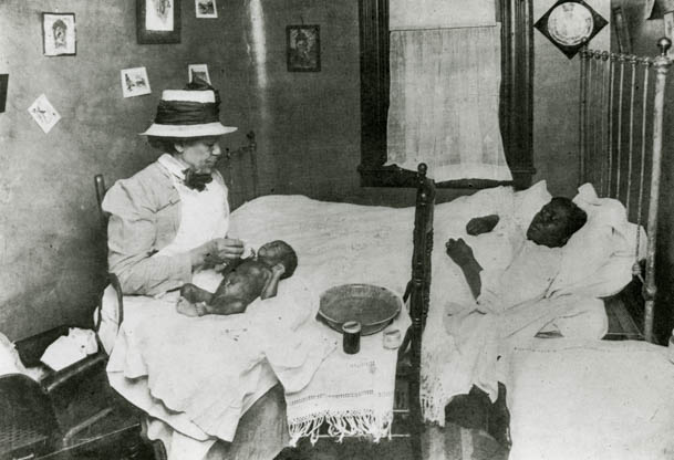 Infirmière afro-américaine de Henry Street Settlement visite mère et bébé, ca. 1910