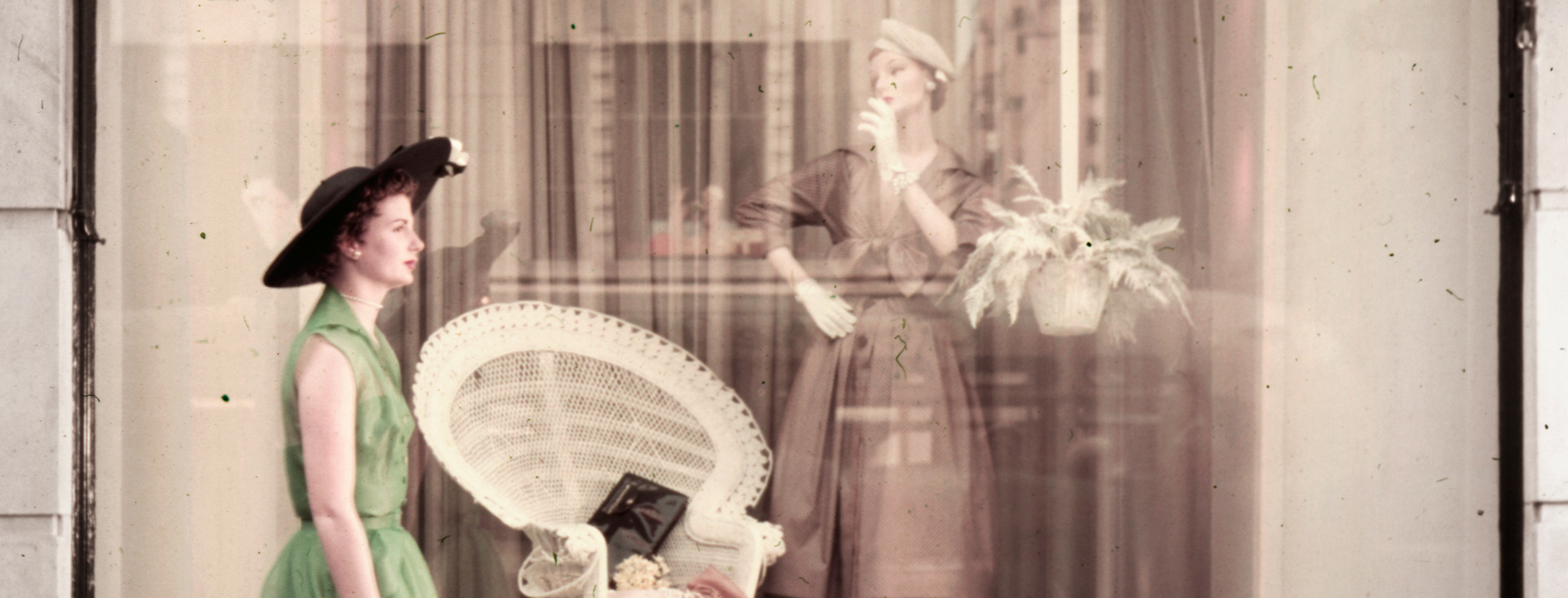 Woman walking past a department store window display.