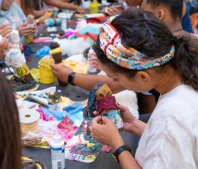 A young girl makes art at a table. 