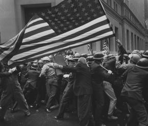A crowd of protesters at a Pro-Vietnam-War demonstration holding a large American flag