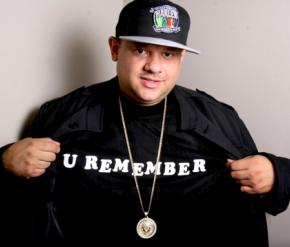 Image of DJ Ted Smooth wearing black hat and shirt that reads" U REMEMBER" 