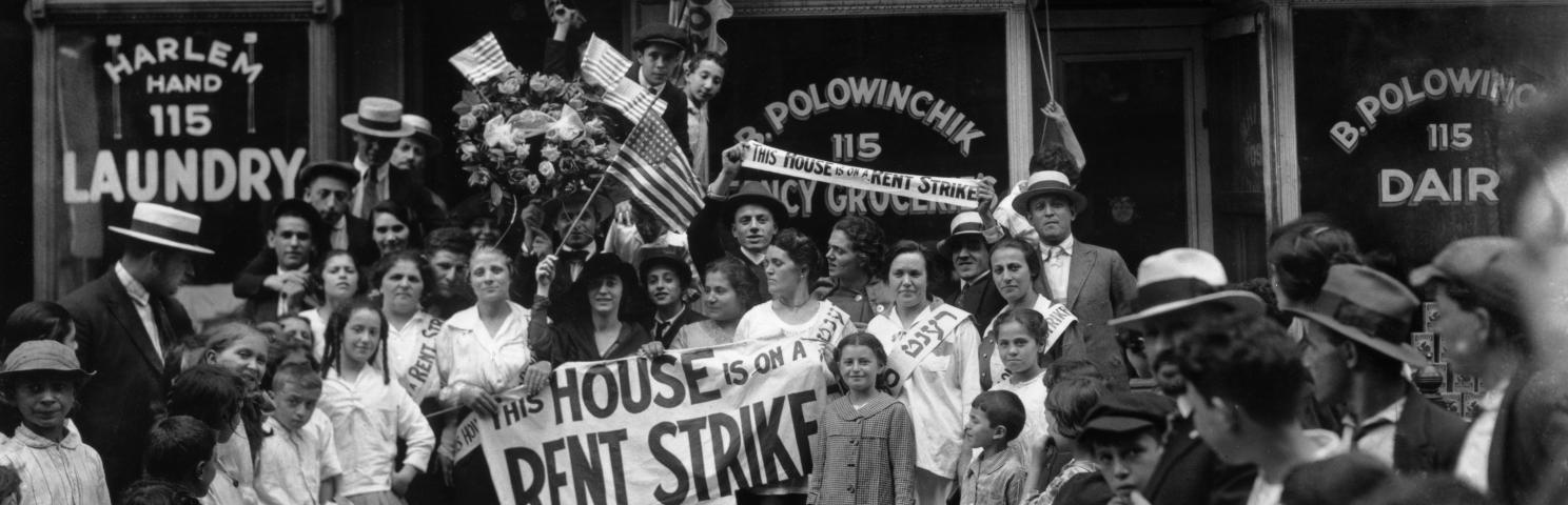 A group of men, women, and children during a rent strike in Harlem.