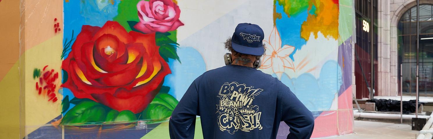 Christopher "Daze" Ellis looking at a painting he is creating at 550 Madison