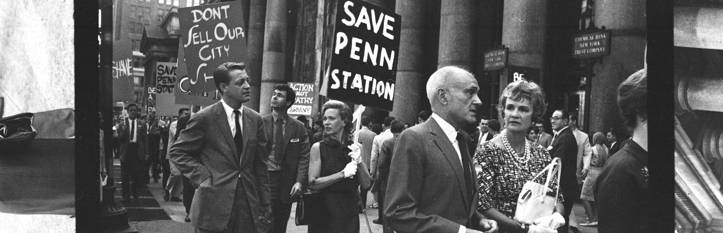 A group of marchers hold signs protesting the demolition and renovation of Penn Station