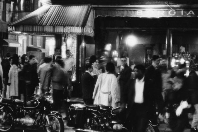 Photograph by Fred W. McDarrah of a motion-filled crowd outside the Caffe Borgia in Greenwich Village