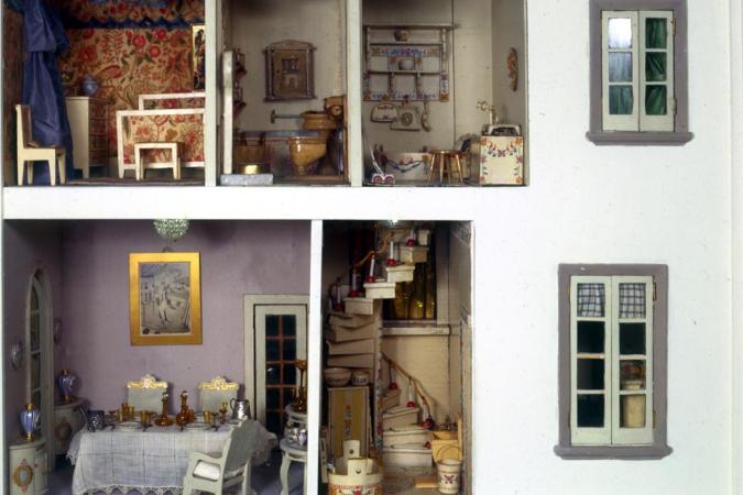 Vista de duas janelas, escadas e sala de jantar mobiliada, banheiro e quarto na casa de bonecas Stettheimer