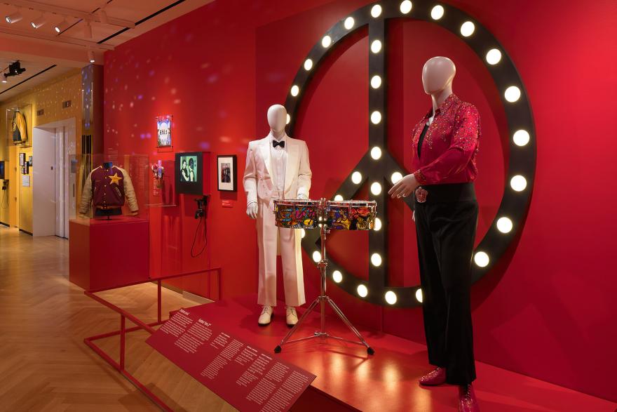 Installation of Urban Stomp with two mannequins in front of red wall
