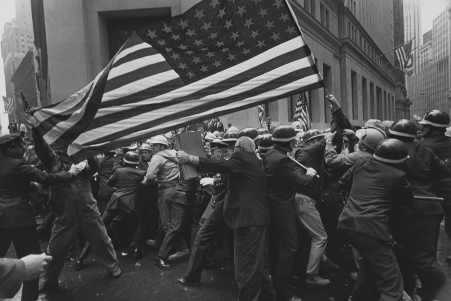 A crowd of protesters at a Pro-Vietnam-War demonstration holding a large American flag