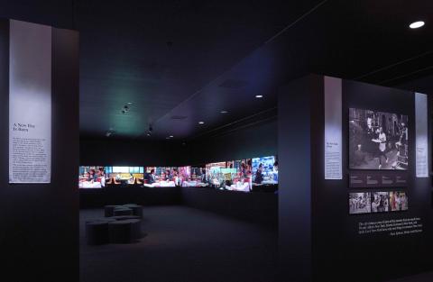 A dark room with several large screens. 