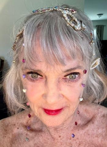 A woman with a sparkly headband poses for the camera. 