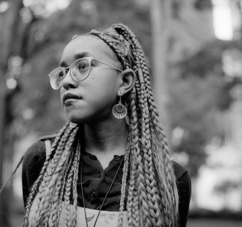 Une femme à lunettes regarde sur le côté.