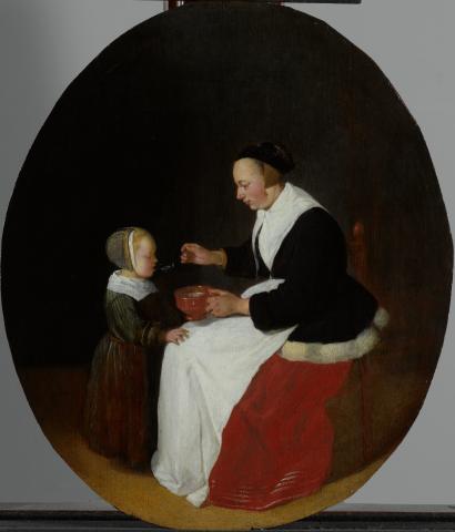 An oval-shaped painting in the Dutch genre painting style of a woman feeding a young child liquid from a cup and spoon. 