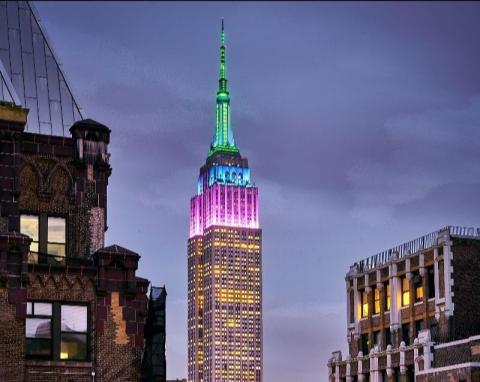 Foto de la luz del Empire State Building en violeta, azul y verde en honor al Centenario del Museo