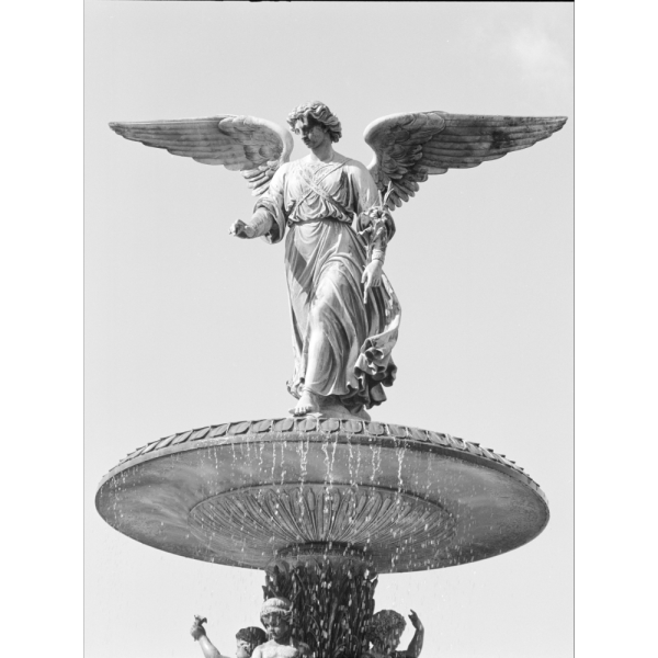 Bethesda Fountain: A black-and-white photograph shows a winged angel statue standing atop a large fountain, arms gently extended as water cascades below against a bright, open sky.