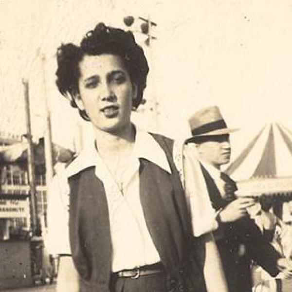 A woman stands on the Coney Island boardwalk.