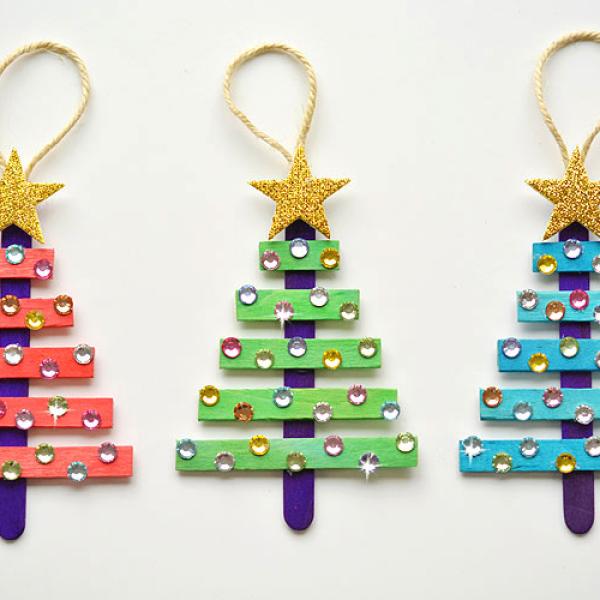 Red, green, and blue ornaments made from popsicle sticks and decorated with gemstones.