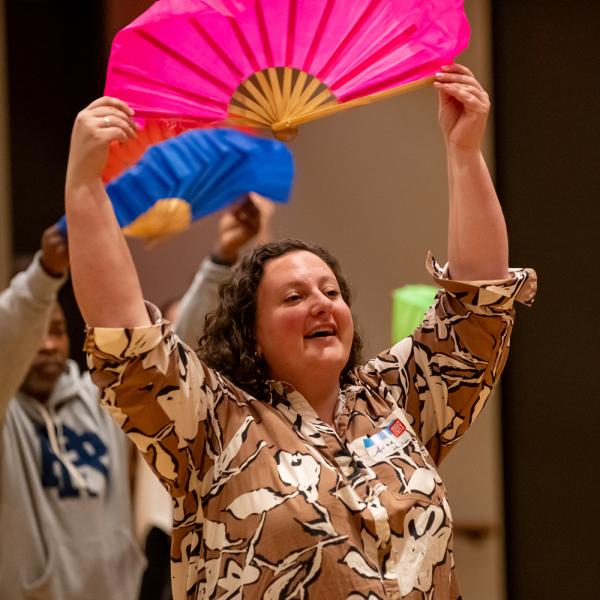 Two people holding colorful paper fans above their heads.