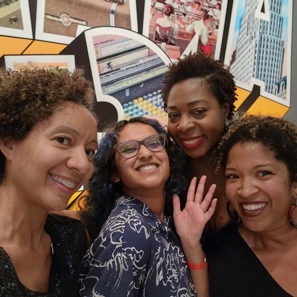 Four women pose towards the camera.