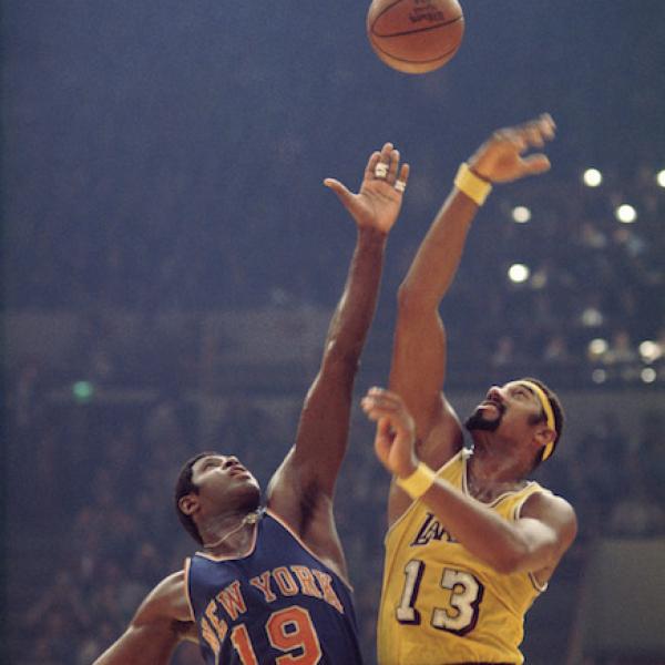 Willis Reed and Wilt Chamberlain tip off at the start of a basketball game