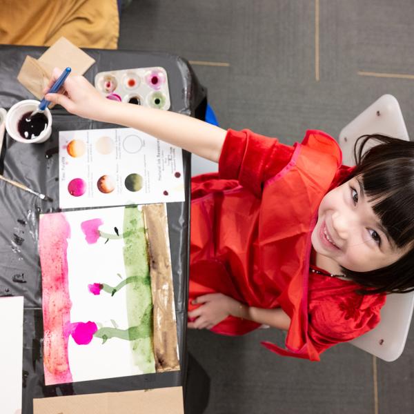 One child creating an artwork with watercolor paint.