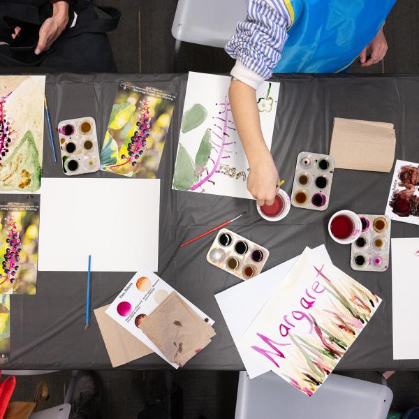 Several children creating an artwork with watercolor paint.
