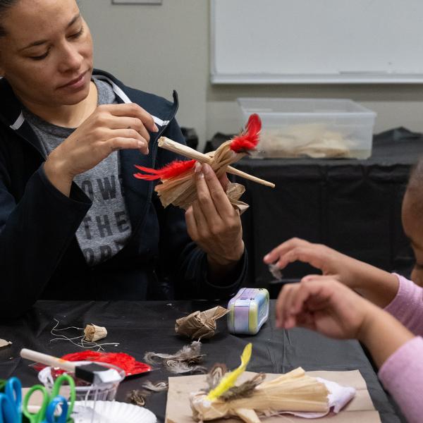 An adult and a child creating an artwork together.