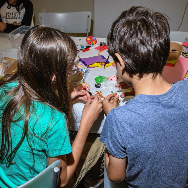 Two children work on an art project.