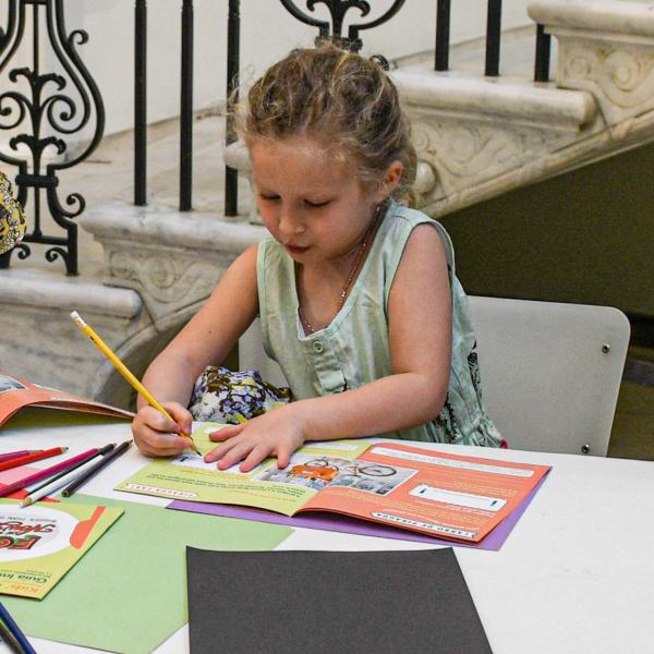 A child writes in a booklet. 