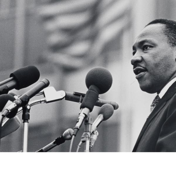Image of Dr. Martin Luther King Jr. speaking into several microphones.