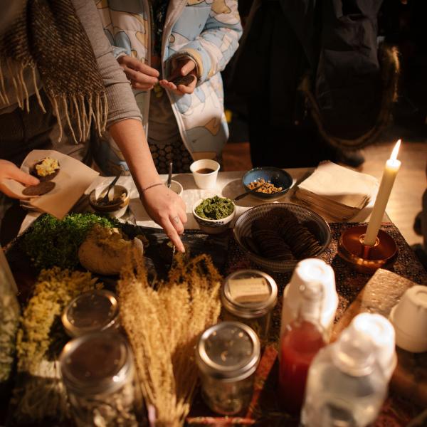 Imagen de ingredientes alimentarios en una mesa con gente reunida alrededor