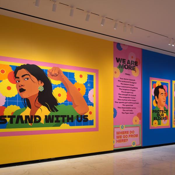 Captura de instalação de "Raise Your Voice", mostrando desenhos vibrantes e coloridos de indivíduos com texto.