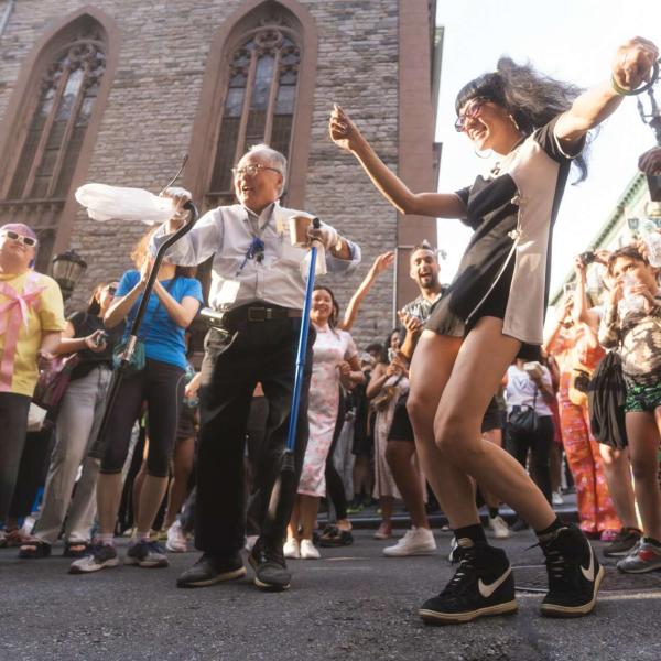 People old and young dancing in the street
