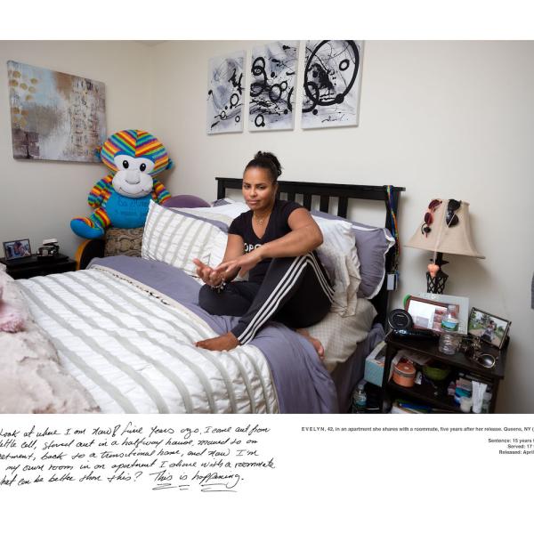 A woman sits on a bed.