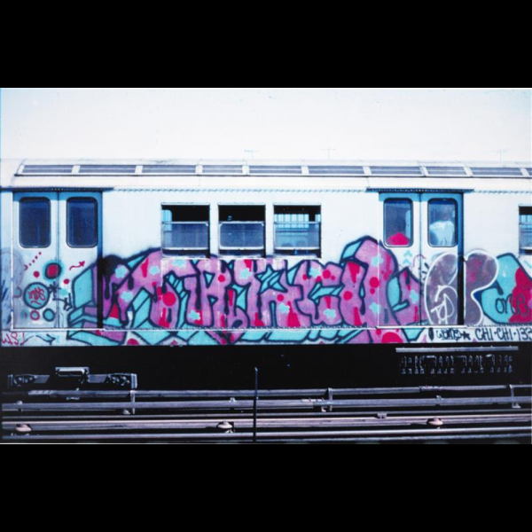 Image of Graffiti writing on a subway car on outdoor train tracks