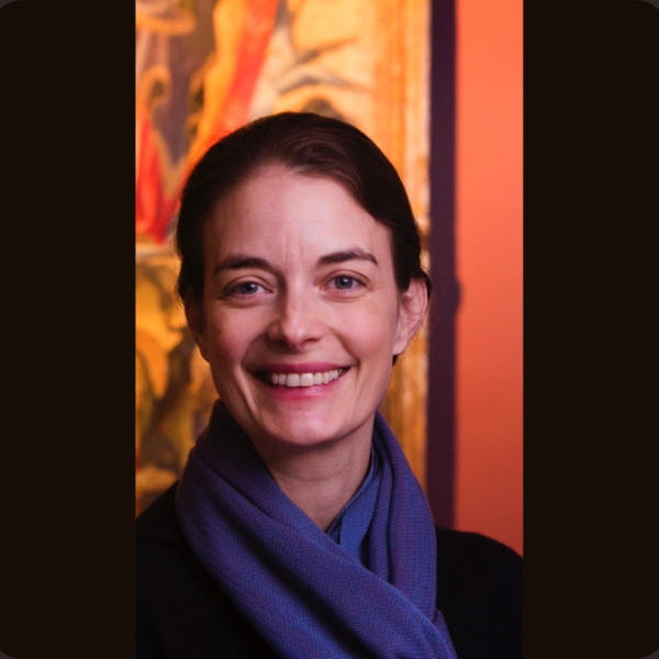 Woman in a purple scarf smiling in front of an orange background